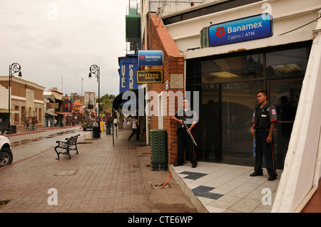 Les gardes de sécurité d'une banque garde le long de la Calle Obregon à Nogales, Sonora, Mexique, en face de la frontière de Nogales, Arizona, USA. Banque D'Images