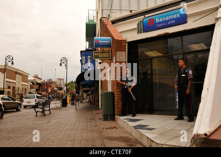 Les gardes de sécurité d'une banque garde le long de la Calle Obregon à Nogales, Sonora, Mexique, en face de la frontière de Nogales, Arizona, USA. Banque D'Images