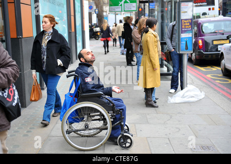 Un homme handicapé soulève de son fauteuil roulant à Knightsbridge Londres. Banque D'Images