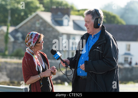 Veteran BBC Radio Cymru presenter HYWEL GWYNFRYN interviewer une femme vivent sur la radio de la langue galloise, le Pays de Galles UK Banque D'Images