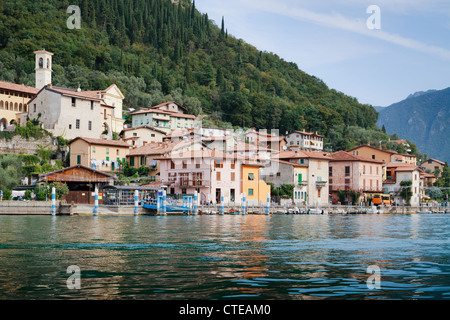 Ville de Peschiera de Lago d'Iseo, waterfront avec église du 18ème siècle sur la colline derrière, sur l'île boisée de Monte Isola. Banque D'Images