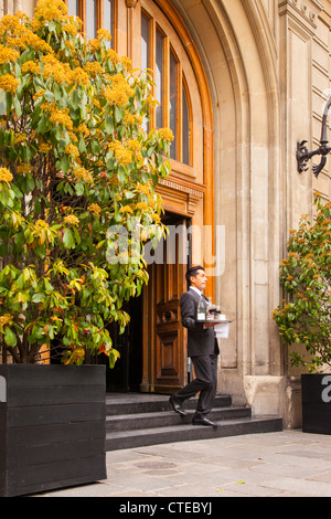 Offre d'apporter des boissons de la cuisine au sidewalk cafe, Paris France Banque D'Images