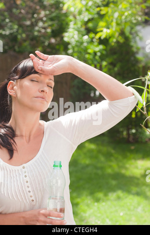 Une femme assoiffée dans le jardin avec un plan d'eau Banque D'Images