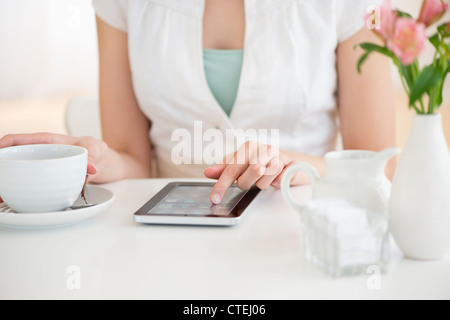 USA, New Jersey, Jersey City, Midsection of young woman using tablet pc in restaurant Banque D'Images