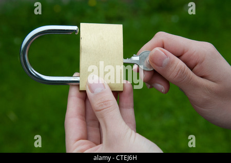 Cadenas et clé en mains d'une jeune femme Banque D'Images