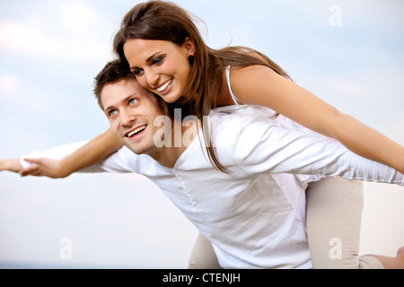 Portrait d'un jeune couple sympathique bénéficiant de la compagnie des autres avec le beau ciel d'été en arrière-plan Banque D'Images