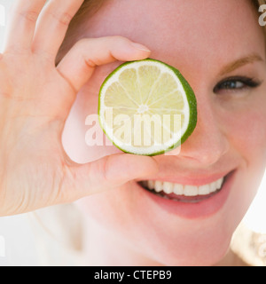 USA, New Jersey, Jersey City, Portrait of woman holding tranche de lime Banque D'Images