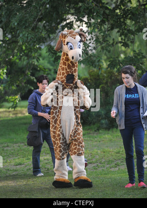 Personne habillé en tenue que girafe wacky foules sortent pour regarder les Jeux Olympiques du relais de la flamme à Brighton Banque D'Images