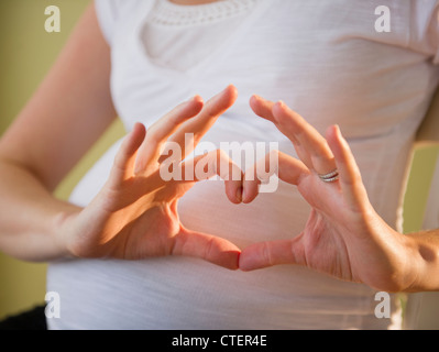 USA, New Jersey, Jersey City, pregnant woman making heart shape with hands Banque D'Images