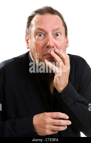 Personnes âgées avec un homme psychopathe wild eyed regard dans ses yeux tient son visage avec une expression choquée. Banque D'Images