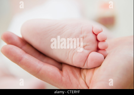 USA, New Jersey, Jersey City, Close up of mother's hand holding bébé fille (6-11 mois) foot Banque D'Images