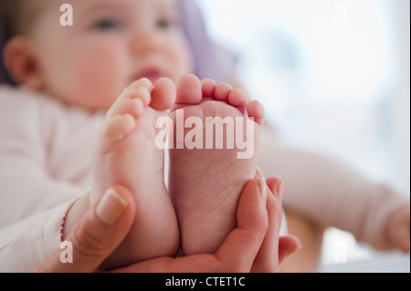 USA, New Jersey, Jersey City, Close up of mother's hand holding bébé fille (6-11 mois) pieds Banque D'Images