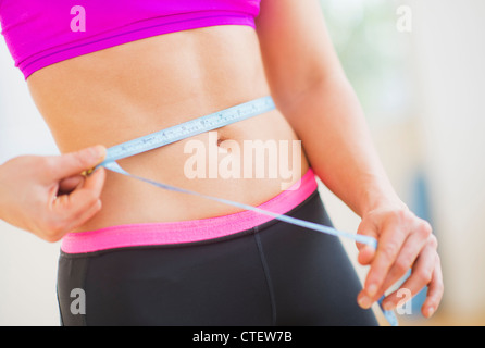 USA, New Jersey, Jersey City, Close up of woman measuring elle-même avec un ruban à mesurer Banque D'Images