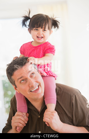 USA, New Jersey, Jersey City, Father carrying baby daughter (12-17 mois) sur les épaules Banque D'Images