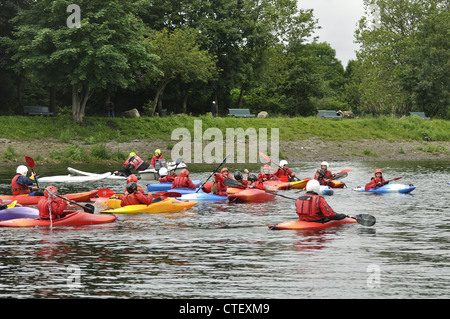 Groupe de canoes paddled par de jeunes enfants avec moniteur veillaient sur le réservoir inférieur gorton, Debdale Park, Manchester Banque D'Images