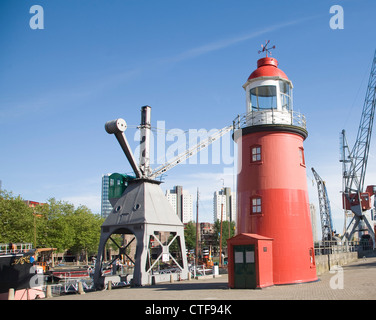 Grues et historique phare rouge dans le havre musée, Leuvehaven, Rotterdam, Pays-Bas Banque D'Images