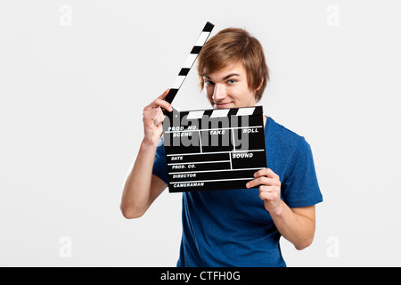 Casual young man holding a deck, sur un fond gris Banque D'Images