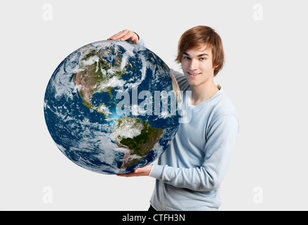 Beau Jeune homme tenant la planète terre sur ses mains, isolated on white Banque D'Images