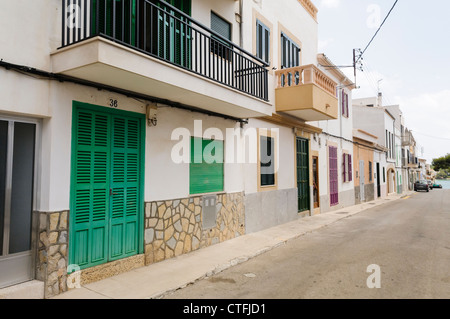 Maisons avec des volets sur les fenêtres sur une rue vide dans la ville espagnole de Portocolom, Mallorca/Majorca Banque D'Images