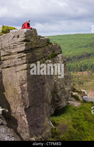 Un randonneur couché en profitant de la vue sur la campagne environnante depuis le haut de Simonside Crags près de Rothbury, Northumberland, England Banque D'Images