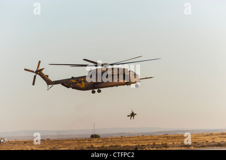 Une armée de l'Air hélicoptère CH-53 au cours de formation en recherche et sauvetage, en relevant un infirmier avec une 'victime' sur une civière. Banque D'Images