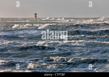 Les Pays-Bas, IJmuiden, tempête. Les vagues déferlent contre phare ou phare. Banque D'Images