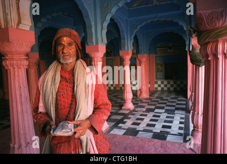 Prêtre hindou tenant un livre religieux. Il est à l'intérieur d'un temple (Inde) Banque D'Images