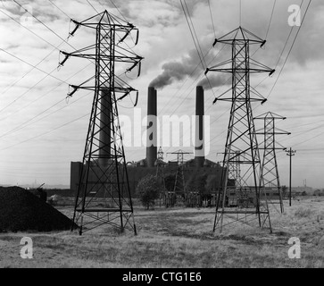 1950 INDUSTRIAL POWER PLANT volutes de fumée à produire de l'ÉLECTRICITÉ DES TOURS DE LA LIGNE D'ALIMENTATION EN PREMIER PLAN Banque D'Images