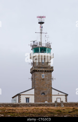 Vieux phare en pierre avec des équipements modernes à jour terne. Cape Ra, (Pointe du Raz), point le plus occidental de la France Banque D'Images