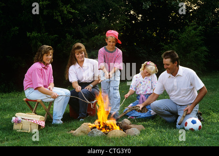 La famille des années 1990, les hot-dogs DE GRILLAGE SUR DES BÂTONS Plus de feu de camp Banque D'Images