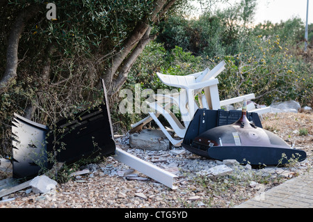 Chaises de patio et de télévision sous-évaluées par le côté d'une route Banque D'Images