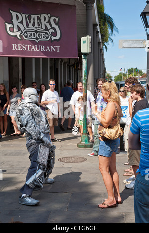 Artiste de rue argent peint divertit les touristes sur le trottoir dans le quartier français de New Orleans, LA Banque D'Images