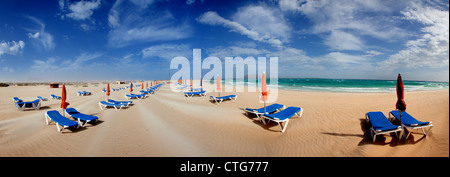 Parasol et transats sur la plage de sable de l'île de Fuerteventura, Espagne Banque D'Images