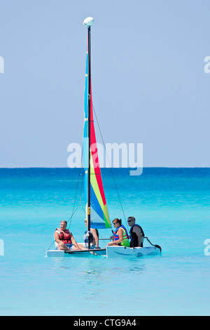 Quatre personnes sur catamaran Hobie Cat dans les eaux de Half Moon Cay, Bahamas Banque D'Images