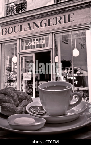 B&W rétro parisien typique petit-déjeuner continental composé de café et croissant à l'extérieur de la Boulangerie de renommée mondiale, Montmartre, Paris, France Banque D'Images