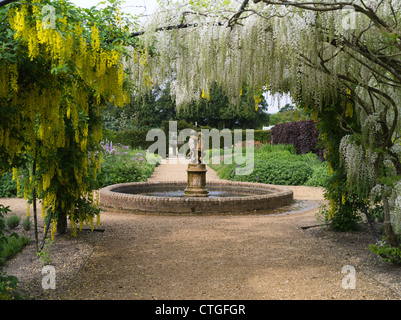 dh jardin de fleurs victorien BEAULIEU JARDINS HAMPSHIRE English Country Water Fontaine avec étang blanc jaune Laburnum fleur arc personne uk angleterre Banque D'Images