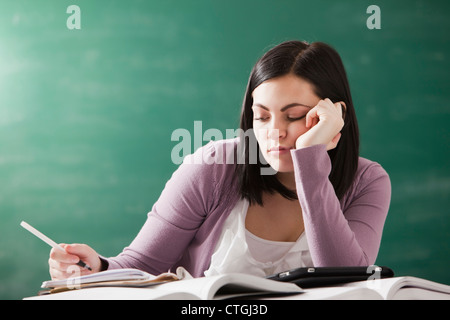 Ennuyer Caucasian student doing homework Banque D'Images