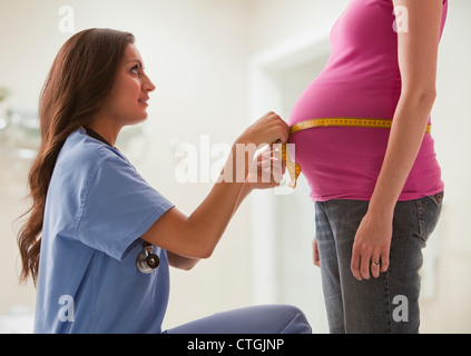 La mesure de l'infirmière de l'estomac de la femme enceinte Banque D'Images