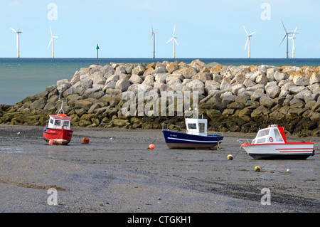 Blocs de béton de type Dolos ou Dolosse dans les défenses des parois de la mer brise-lames formant un petit port avec des éoliennes off-shore au-delà près de la baie Colwyn Banque D'Images