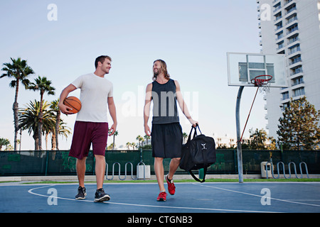 Les hommes de race blanche marche sur terrain de basket-ball Banque D'Images