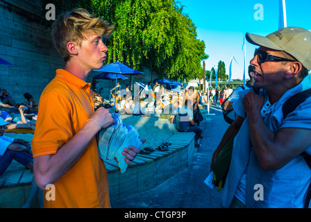 Paris, France, public urbain appréciant les événements publics, Paris Beach, 'Paris plages', dans la ville Seine plage, Guide parlant aux touristes, adolescents emplois, aider les touristes france, garçons adolescents parlant Banque D'Images