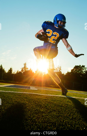 Caucasian football player running with ball Banque D'Images