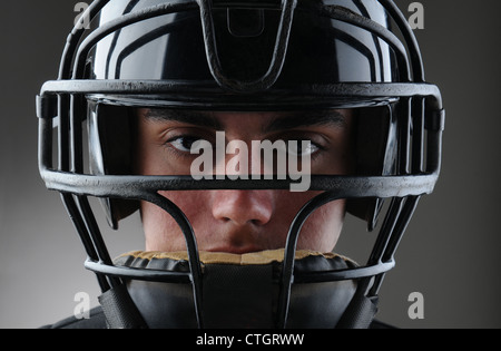 Libre d'un homme de baseball avec son masque de protection. Format horizontal avec une lumière sur fond gris foncé. Banque D'Images