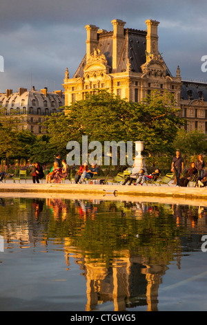 Détente à l'étang dans le Jardin des Tuileries avec musée du Louvre au-delà, Paris France Banque D'Images