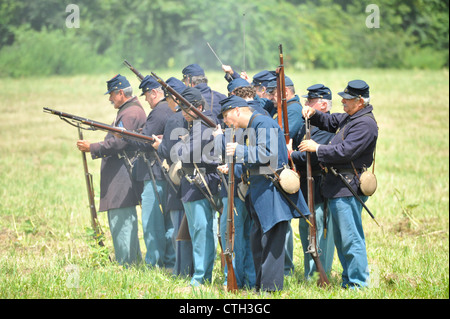 Old Bethpage, New York, USA - 21 juillet 2012 : les troupes nettoyer les canons de leurs mousquets entre séries de coups, au Camp Scott, un Banque D'Images