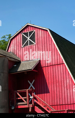 Grange rouge vif sur la ferme rurale contre ciel bleu avec l'exemplaire de l'espace. Banque D'Images