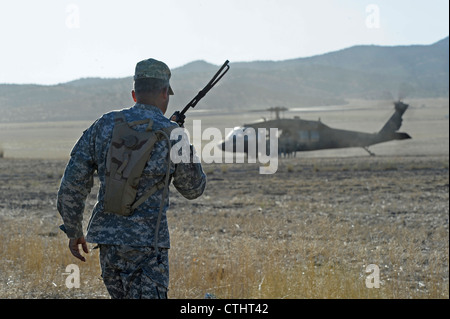 Sgt. Le Maj Moises Moniz, 2e bataillon le 19e Groupe des forces spéciales fait appel à deux hélicoptères UH-60L Blackhawk du détachement 2, Compagnie C, 1er Bataillon de l'aviation de soutien général, 171e Régiment d'aviation, 21 juin 2012. Moniz a surveillé les conditions du vent, suivi les États des cavaliers et régulé le rythme des opérations de terrain d'aviation par le biais d'une communication radio bidirectionnelle avec les pilotes Blackhawk. Banque D'Images