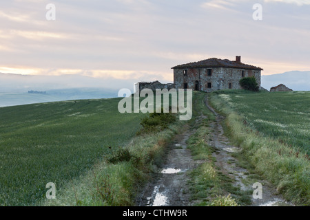 Le brouillard du matin vue sur ferme abandonnée à la vallée d'Orcia en Toscane, Italie. Banque D'Images