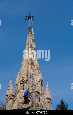 Steeplejack au travail sur la flèche de l'église à Tobermory sur l'île de Mull en Ecosse Banque D'Images