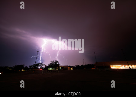 Le double coup de foudre d'un orage nocturne plus de stationnement d'un centre commercial. Banque D'Images